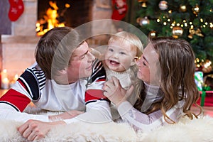 Happy family - mother, father and baby little boy playing in the winter for the Christmas holidays
