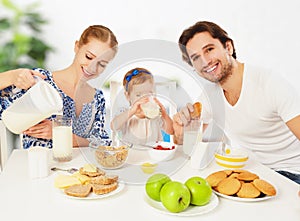 Happy family mother, father, child baby daughter having breakfast
