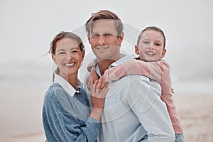 Happy family, mother and father with child at a beach enjoying winter holiday vacation and bonding outdoors. Smile, mom