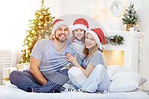 Happy family mother father and child on Christmas morning in bed