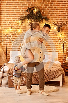 Happy family mother father and child on Christmas morning in bedroom playing and have a fun