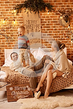 Happy family mother father and child on Christmas morning in bedroom playing and have a fun