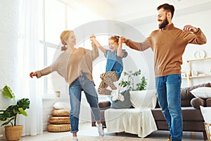 Happy family mother father and child daughter dancing at home