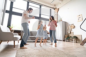 Happy family mother father and child daughter dancing at home.