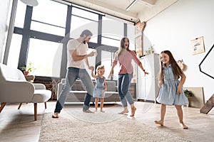 Happy family mother father and child daughter dancing at home.