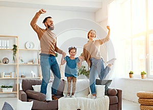 Happy family mother father and child daughter dancing at home photo
