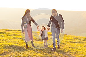 Happy family, mother father and child daughter on nature on sunset