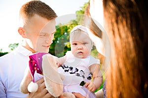 Happy family: mother father and child daughter on nature on sunset