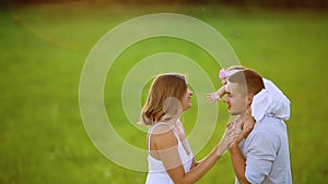 Happy family: mother father and child daughter on nature on sunset