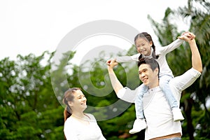 Happy family: mother, father, child daughter at park. Family relaxing on holiday