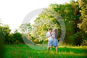 Happy family: mother father and child daughter in the park on sunset