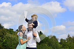 Happy family mother father and child son laughing and havig fun with toy paper plane. Child playing with toy airplane
