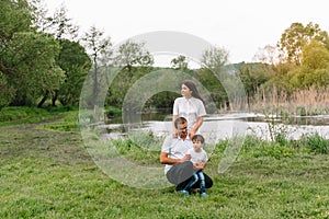 Happy family: mother father and child son on nature on sunset. Mom, Dad and kid laughing and hugging, enjoying nature outside.