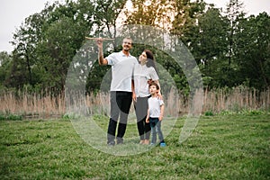 Happy family: mother father and child son on nature on sunset. Mom, Dad and kid laughing and hugging, enjoying nature