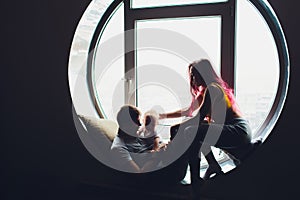 happy family of mother, father and child son playing and cuddling at home on floor near a big window.