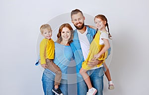 Happy family mother father and children daughter and son  near an   grey blank wall photo