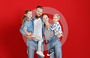 Happy family mother father and children daughter and son  near an   red wall