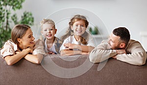 Happy family mother father and children at home on couch