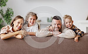 Happy family mother father and children at home on couch