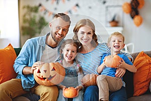 Happy  family mother father and children prepare for Halloween decorate  home with pumpkins,  laughing and  play