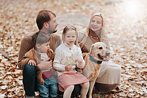 Happy family: mother, father, children son, daughter and dog labrador walking and have fun in park. Warm memories. Relations Love