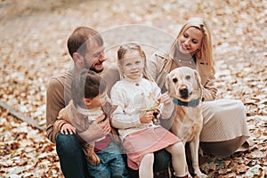 Happy family: mother, father, children son, daughter and dog labrador walking and have fun in park. Warm memories. Relations Love