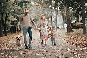 Happy family: mother, father, children son, daughter and dog labrador walking and have fun in park. Warm memories. Relations Love