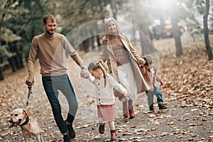 Happy family: mother, father, children son, daughter and dog labrador walking and have fun in park. Warm memories. Relations Love