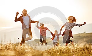 Happy family: mother, father, children son and daughter jumping on sunset