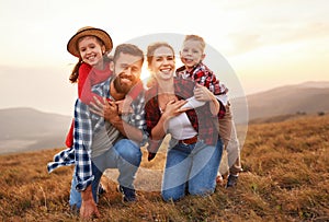 Happy family: mother, father, children son and daughter on nature on sunset