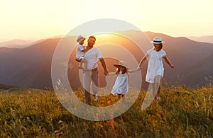 Happy family: mother, father, children son and daughter on sunset