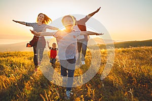 Happy family: mother, father, children son and daughter on sunset