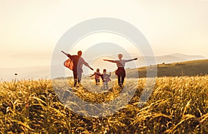 Famiglia felice madre, un figlio un poggiapiedi un saltando sul tramonto 