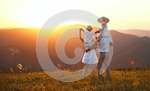 Happy family: mother, father, children son and daughter on sunset