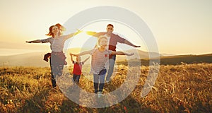 Happy family: mother, father, children son and daughter on sunset