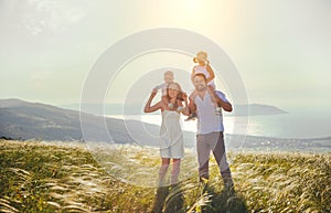 Happy family: mother, father, children son and daughter on sunset