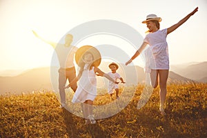 Happy family: mother, father, children son and daughter on sunset