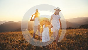 Happy family: mother, father, children son and daughter on sunset