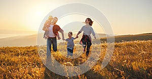 Happy family: mother, father, children son and daughter on sunset