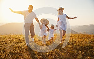 Happy family: mother, father, children son and daughter on sunset