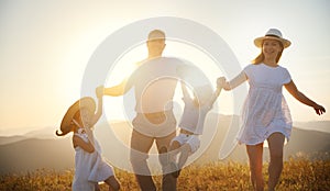 Happy family: mother, father, children son and daughter on sunset