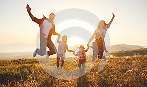 Happy family: mother, father, children son and daughter on sunset