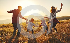 Happy family: mother, father, children son and daughter on sunset