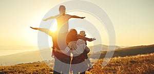 Happy family: mother, father, children son and daughter on sunset