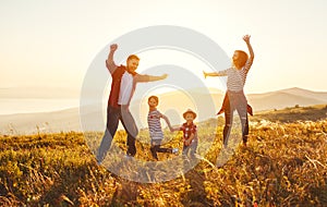 Happy family: mother, father, children son and daughter on sunset