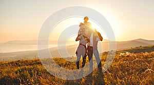 Happy family: mother, father, children son and daughter on sunset