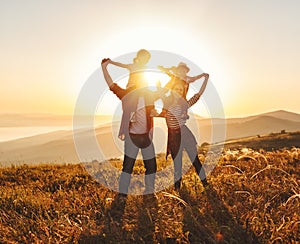 Happy family: mother, father, children son and daughter on sunset