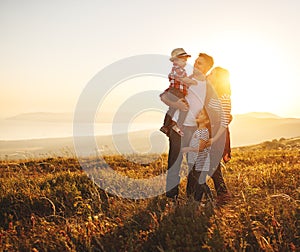 Happy family: mother, father, children son and daughter on sunset