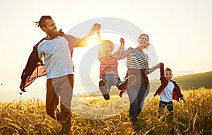 Happy family: mother, father, children son and daughter on sunset