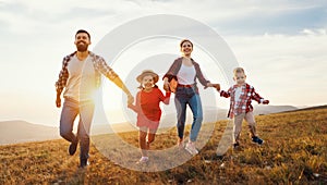 Happy family: mother, father, children son and daughter on sunset